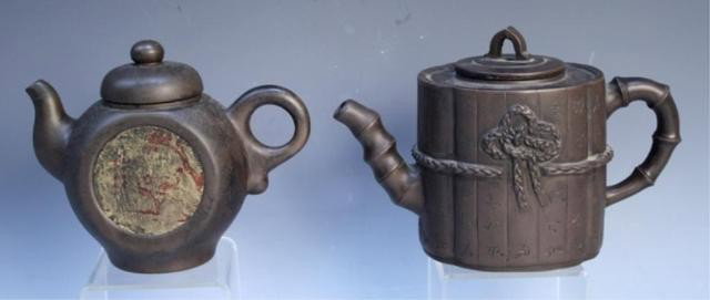Two Chinese Yixing Teapots with Calligraphy: Two brown yixing teapots both with calligraphy, one with a small red figure drawing inset on the side, China; marked. Dimensions: Larger: 5" H x 7-1/2" W x 3-1/2" D, Smaller: 4-1/2" H x 6-1/4" W x 2-1