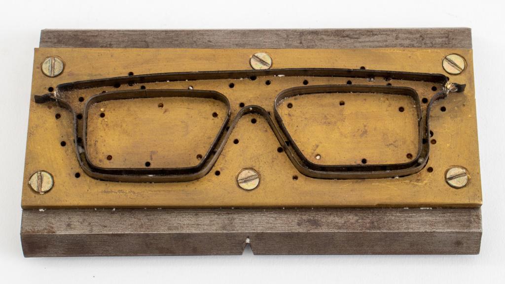 Industrial Eyeglass Frame Cutting Die, 1960s: American Industrial eyeglass frame cutting die, ca. 1960s, brass and steel, used as a paperweight. 6.75" L x 3.75" D