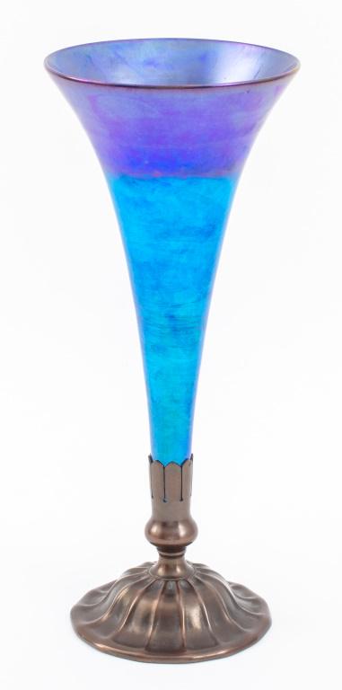 L.C. Tiffany Blue Favrile Glass Trumpet Vase: Louis Comfort Tiffany (American, 1848-1933) Art Nouveau blue favrile glass trumpet vase with electric azure blue hues to base and iridescent purple indigo tones to flaring lip, the glass insert mounte