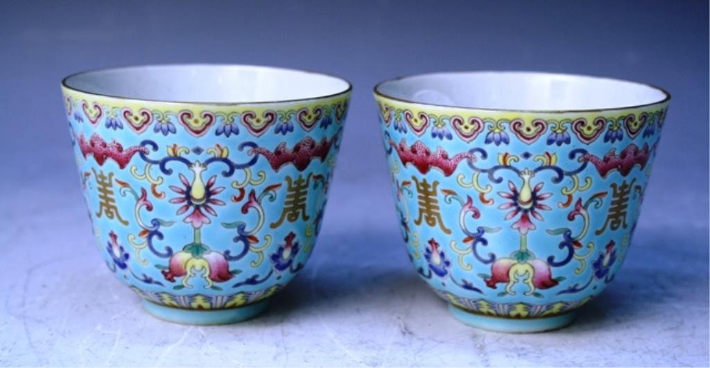 Chinese Turquoise Ground Famille Rose Cup Pair: Turquoise ground famille rose cup pair with bats and longevity symbol, China; marked. Dimensions: each 2-3/4"H x 3-3/8"