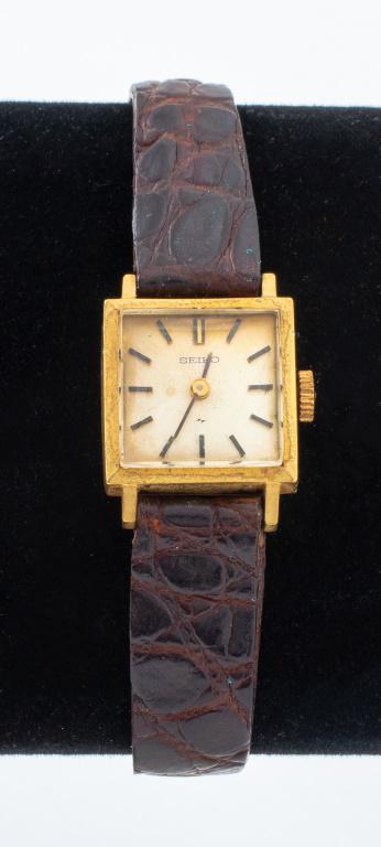 Vintage Seiko 14K Yellow Gold Watch: Seiko watch, 14K yellow gold case, featuring a cream colored square dial with gold baton indices and hands, powered by a mechanical 17 jewel Seiko wind-up movement, worn with an adjustable leather str