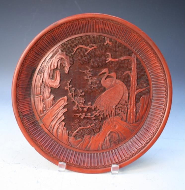 Chinese Carved Cinnabar Dish 18th C.: Carved dish with cranes among trees and mountains, cinnabar lacquer, China, eighteenth century; unmarked. Dimensions: 1"H x 12" diameter