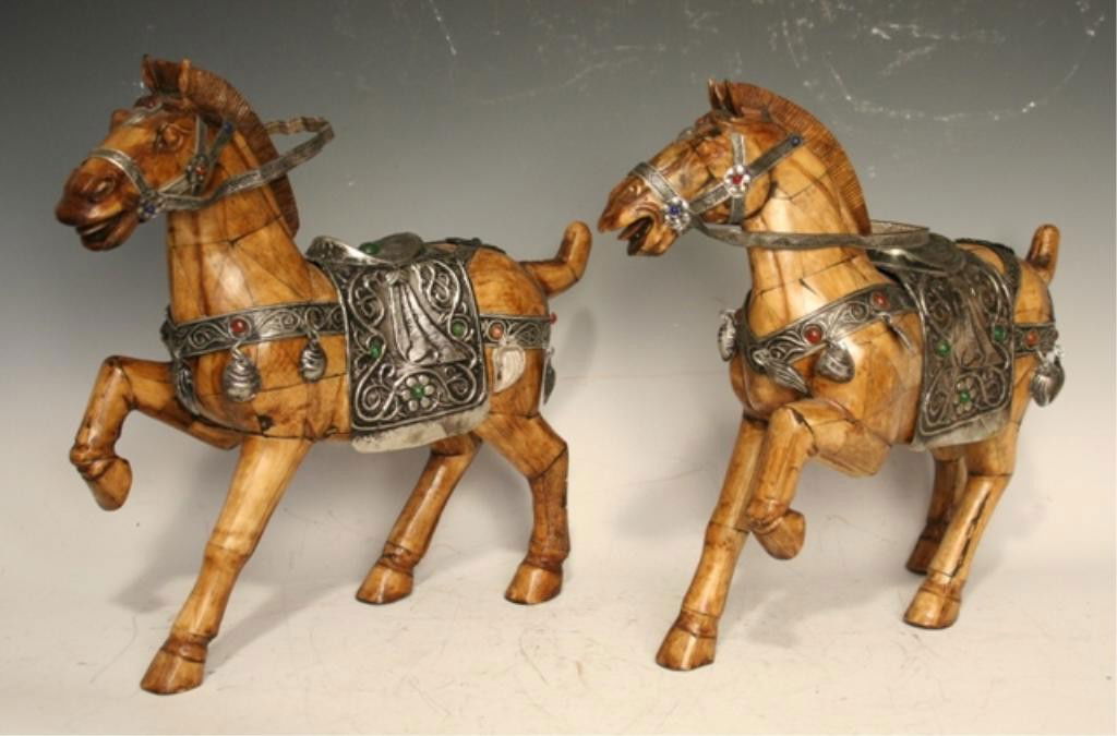 Pair of Ivory/Bone Horses with Metal Saddles: Pair of prancing horse sculptures with repousse saddles, ivory or bone and metal; unmarked. Dimensions: 13-1/4"H x 14-1/2"W x 4"D and 12-1/2"H x 14-1/2"W x 4"D