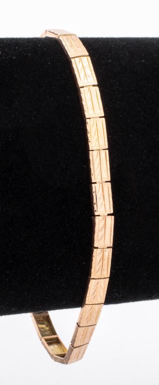 Yellow Gold Bracelet: 10K yellow gold bracelet, brightly polished and engraved, joined with box and tongue clasp with figure 8 safety, marked: " 10K '. Measuring approx. 7 1/2" x 3/8", approx. 3.7 dwt.