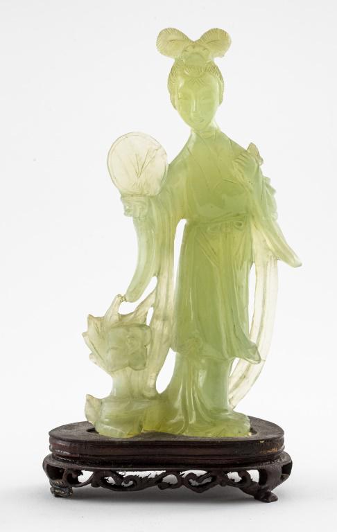 Chinese Carved Jade Figure of a Beauty: Chinese carved jade sculpture of a beauty holding a fan, attached to a carved wood base. Overall: 8.75" H x 4.5" W x 2.5" D. Condition: Scattered chip losses, cracks, and areas of repair.