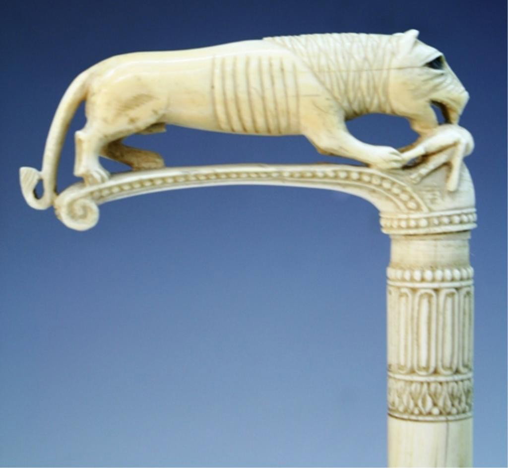 Ivory Cane Topper with Lion and Gazelle: Cane topper with carved lion attacking a gazelle and other incised designs, ivory and metal; unmarked. Dimensions: 6-1/2"H x 4"W