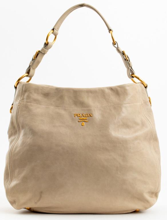 Prada Vitello Daino Leather Bag: Prada Vitello Daino beige leather purse with top handle and gold-tone metal hardware, marked "PRADA / MILANO / DAL 1913" to exterior and inside. 13" H x 14" W x 7" D.