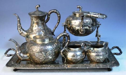 7 Pc. Cheong Shing Chinese Export Silver Tea Set: Seven piece Cheong Shing Chinese export silver tea set with cherry blossom branches and birds; marked. Dimensions: 21-5/8"L x 12-3/4"W x 1-1/4"H (tray), 9"diameter x 9"H (large footed-pitcher), 10-1/2