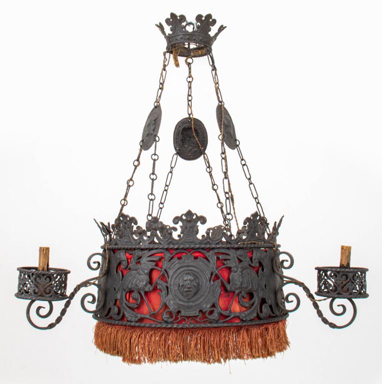 Spanish Baroque Revival 3-Arm Iron Chandelier: Spanish Baroque Revival three armed chandelier comprising sheet iron with Gothic figural repousse decoration, the three light bulb fittings of candlestick form, with a red brocade upholstered shade, i