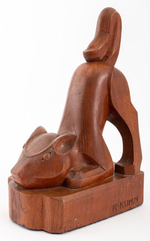 Signed Arts & Crafts Wooden Animalier Sculpture: Arts and Crafts hardwood animalier sculpture depicting a playful squirrel creature, signed "R. KUHN" to side, leather covered to underside. 9" H x 4.25" W x 5.75 D.