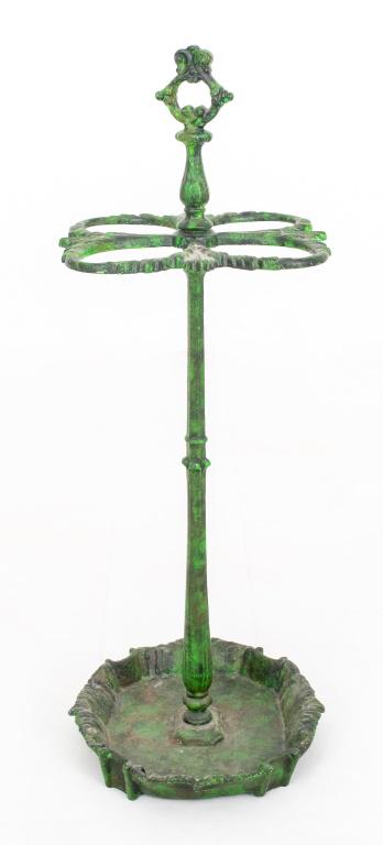 Green Patinated Cast Iron Umbrella Stand: Green patinated cast iron umbrella stand, with handle and four chambers on a support above a circular base. 28" H x 12" diameter.