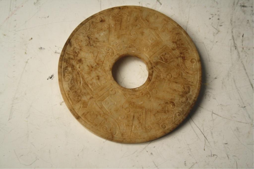 Chinese Carved White Jade Bi Disk Han Dynasty: Carved white jade Bi disk with teote mask motif, China, Han dynasty (206 BCE - 220 CE); unmarked. Dimensions: 5-1/8" diameter x 1/4"D