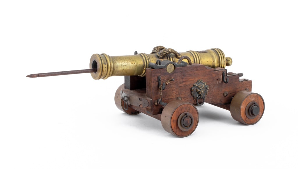 Spanish Cannon Militaria Scale Model: Brass model of a Spanish military cannon, with heraldic arms to chamber, the whole on a wooden gun carriage with lion mounts. 4.25" H x 13" W x 6" D.