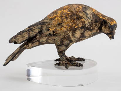 Karl Springer Giltmetal Bird on Lucite Stand: Cast iron bird decorated with a strip of gold leaf, mounted on a custom lucite base made by Karl Springer (American, 1931 - 1991), unmarked. 5" H x 8" W x 4.5" D.