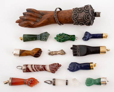 Carved Hardstone, Wood, Metal Figa Hand Charms, 12: Group jewelry lot of twelve figa mano protection amulet pendants comprising one Portuguese silver and wood figa fist pendant, bail marked "Prata 833 / 036 B. A", five with silver mountings, one cast m