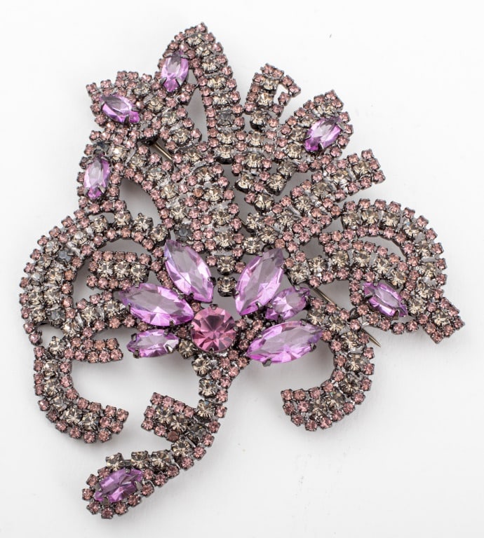 Giorgio Armani Purple Gemstone Mounted Brooch: Giorgio Armani designer costume jewelry pin in the form of a flower and mounted with rhinestones in purple and gray hues, marked "GIORGIO ARMANI" to reverse. 4" L x 3.5" W.