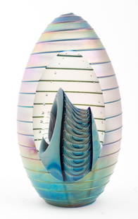 Robert Eickholt Studio Art Glass Sculpture: Robert Eickholt (American, active 1978-2013) studio art glass sculpture of egg form with spiral design and blue iridescent finish, a cutout reveals an inner blue millefiori shape below an arc of