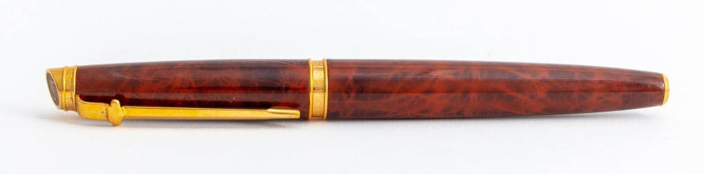 Caran d'Ache "Geneve" 18K Nib Fountain Pen: Caran d'Ache "Geneve" fountain pen, with 18K solid yellow gold nib, all gold-plated accents are "G" 18K gold-plated, having barrel and cap in the famous Caran d'Ache marbled brown coat, wide gold band