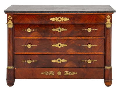 French Empire Ormolu-Mounted Mahogany Commode: French Empire ormolu-mounted mahogany four-drawer commode, circa 1815, with a rectangular black fossilized marble top, above a frieze drawer and three drawers with pulls framed by colonnettes, on