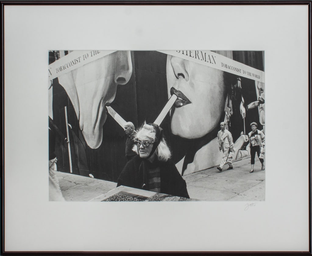 Kathy Yates "Woman by Nat Sherman" Print, 1991: Kathy Yates (American, XX-XXI) "Woman by Nat Sherman" archival inkjet print, 1991, depicting a street scene with figures and centering on a woman wearing sunglasses with curlers in her hair, signed on