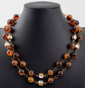 Chanel Double Strand Necklace, 1985: Chanel Double Strand Necklace, 1985, with amber-tone resin beads, gold-tone metal hardware, and faceted rhinestone beads, marked "CHANEL / (c) CC (r) / 1985" to hook clasp closure. 20.5" L. Provenance