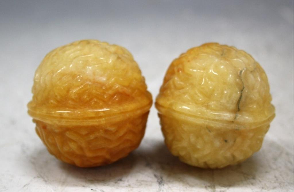 Chinese Pair of Tianhuang Carved Stone Walnuts: Pair of Tianhuang carved stone figural walnuts with a pierced hole on top of each piece in which a string can be put through, China; unmarked. Dimensions: 2" x 2" diameter