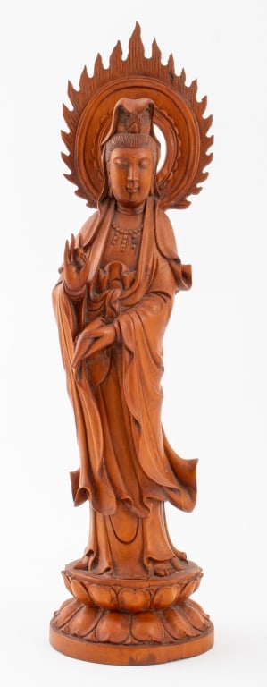 Chinese Carved Wood Guanyin Sculpture: Chinese Carved Wood Guan Yin Sculpture, in flowing robes standing upon a lotus pedestal, holding a vase in left hand, the right in the Shuni mudra, her head encircled by a mandorla aflame. 16.25" H x