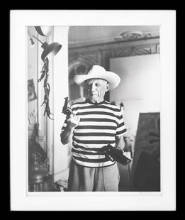 Andre Villers Photograph of Picasso, 1959: Andre Villers (French, 1930-2016) Photograph of Pablo Picasso (Spanish, 1881-1973) wearing a cowboy hat and holding a gun, 1959, signed lower right, stamped and dated to reverse, black metal frame. Im