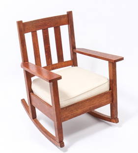 Stickley Style Mission Oak Rocking Arm Chair: Arts & Crafts / Mission oak rocking chair, in the manner of Gustav Stickley (American, 1858-1942), with white cushion seat. 35" H x 26.5" W x 29 D. Keywords: Furniture, Seating, Lounge chair, Vintage