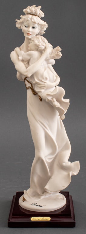Giuseppe Armani "Mother & Child" Porcelain Figure: Giuseppe Armani (Italian, 1935-2006) Porcelain Figure depicting a standing woman with a child in her arms signed to base with Capodimonte marks, circa 1990, raised on a wood base. 13.5" H x 4.5" W x 4