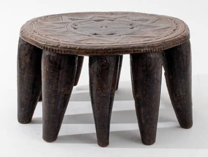 Nigerian Nupe Carved Wood Stool: Nigerian Nupe Carved Wood Stool, featuring stylized sun motif and ten legs. 8" H x 15" Diameter. Provenance: From a Christopher Street collection. Keywords: African art, Relief carving, Geometric, Fur