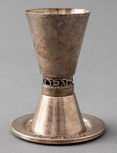 Israeli Silver Kiddush Cup & Underplate: Israeli Silver Kiddush Cup and Underplate, the cup marked "STERLING / MADE IN ISRAEL" and with pierced Hebrew character design above conical foot, the plate with applied Hebrew characters. Weight: