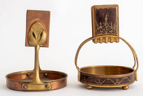 Art Nouveau Mixed Metal Matchbox Strikes, 2: Two Art Nouveau Matchbox Strikes with Trays, one in copper with sinuous organic brass mounts, the other in brass with 'premier partie' brass-inlaid shell sides. Tallest: 5.5" H. Provenance: From a