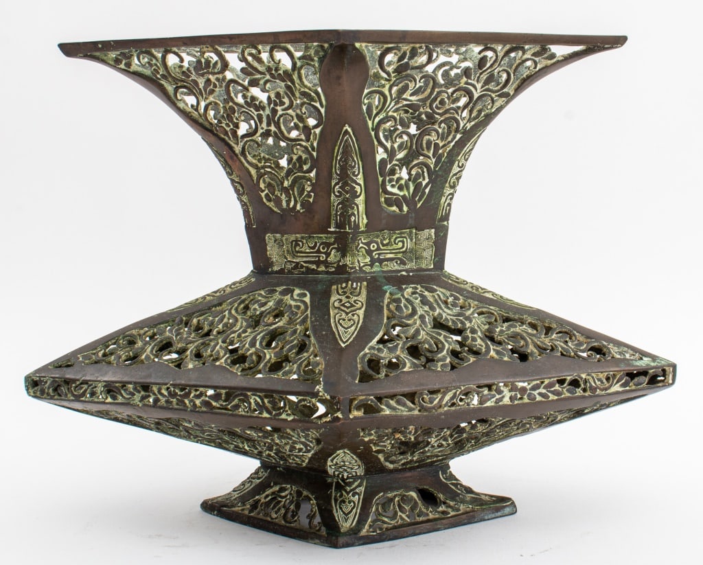 Japanese Bronze Reticulated Vessel in Shang Style: Japanese Patinated Bronze Reticulated Vessel in Chinese Shang Dynasty Style, the lozenge shaped faceted baluster form vessel with pierced panels depicting scrolling foliate motifs, the sides and joint