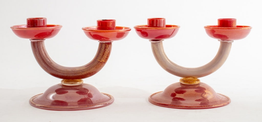 Italian Murano Red Glass Candelabras, Pair: Pair of Italian Murano Red Glass Candelabras with gold flecks, each stamped "Made in Italy" to underside. 5" H x 7" W x 5" D. Provenance: From an Upper East Side collection. Keywords: Lighting, Luxury