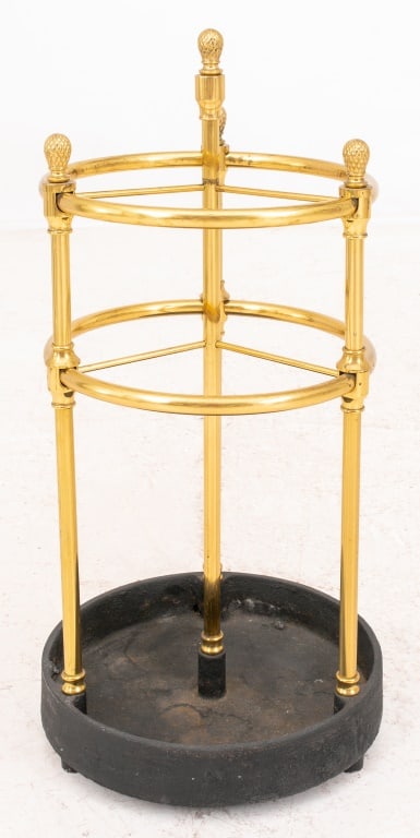 Neoclassical Brass Umbrella Stand: Neoclassical Brass Umbrella Stand, round form with pinecone finials, raised on an ebonized cast iron base. 25.5" H x 12" Diameter. Provenance: From a 17 East 89th Street Estate. Keywords: Furniture, C