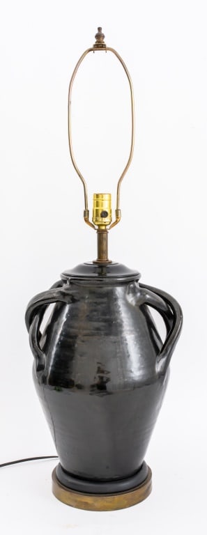 Black Glazed Pottery Amphora Mounted Lamp: Black Glazed Pottery Amphora Vase with Applied Handles Mounted as a Table Lamp, with gilt metal base, apparently unsigned. 32" H X 11" W X 9.5" D. Provenance: Property from a 21 East 87th Street Estat