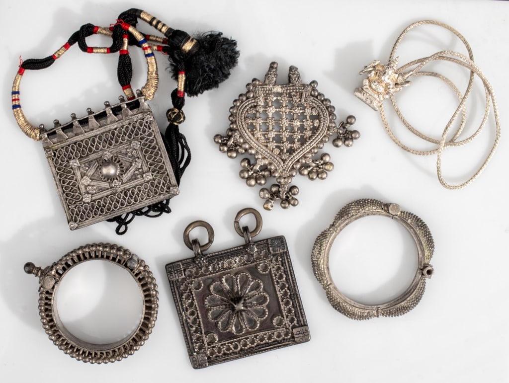Indian Handcrafted Silver Jewelry, 6 Pieces: Group of Six Pieces of Indian Handcrafted Silver Jewelry, circa 19th century and later, comprising: two silver cuff bracelets, two rectangular pendants, one on necklace with gold thread, one reticulat