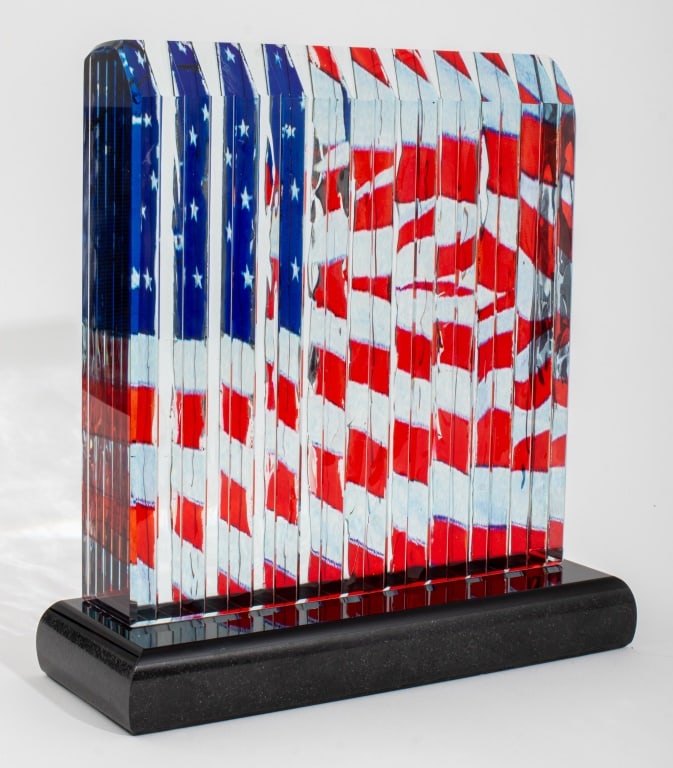 James Randolph American Flag Art Glass Sculpture: James Randolph (American, XX), American Flag, Art Glass Sculpture, cut and laminated crystal glass on black base, etched signature to reverse of base. 11.75" H x 11.25" W x 4.25" D. Provenance: From a