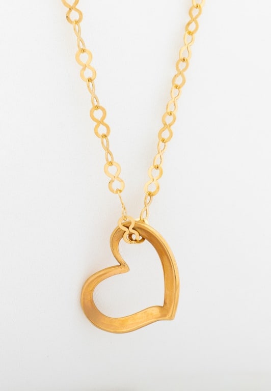 14K Open Heart Pendant on 10K Yellow Gold Chain: 14K Yellow Gold Open Heart Pendant on 10K Yellow Gold Chain, joined by spring ring clasp, marked: "(c) AC 14K (pendant), *1758 AR Italy 10K". Measuring approx. 24" x 1" x 3/4", 2.4 dwt. inclusive. Pro
