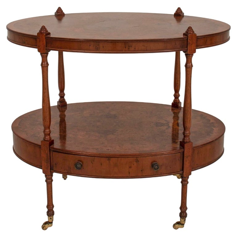 Birdseye Birch Oval Tiered Table: Birdseye Birch Oval Tiered Table, in the 19th century manner, with turned supports on casters. 23" H x 26" W x 17" D. Provenance: From a New York City Collection. Keywords: Furniture, Rolling, Georgia