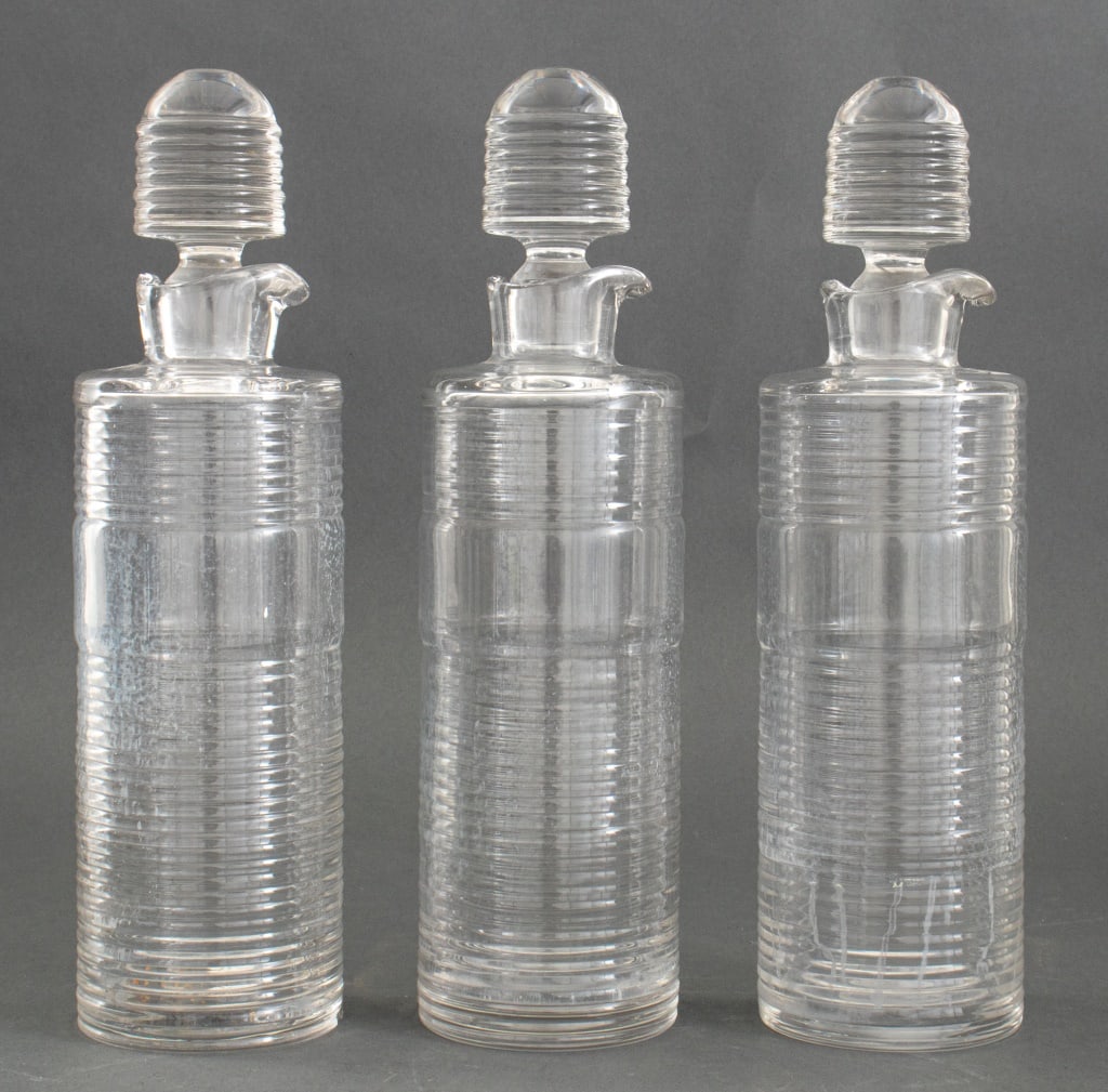 Art Deco Ribbed Glass Decanters, 3: Three Art Deco Ribbed Glass Decanters, with glass stoppers, all illegibly acid-etch stamped to underside. 12.75" H x 3.5" Diameter. Provenance: From an Upper East Side Collection. Keywords: Bar ware, 