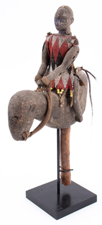 West African Carved Wood Articulated Rider: West African Carved Wood Articulated Mounted Horse Rider, probably Nigeria, the figure wearing a trade bead covered and cowrie shell mounted tunic and with articulated arms and legs, the horse with an