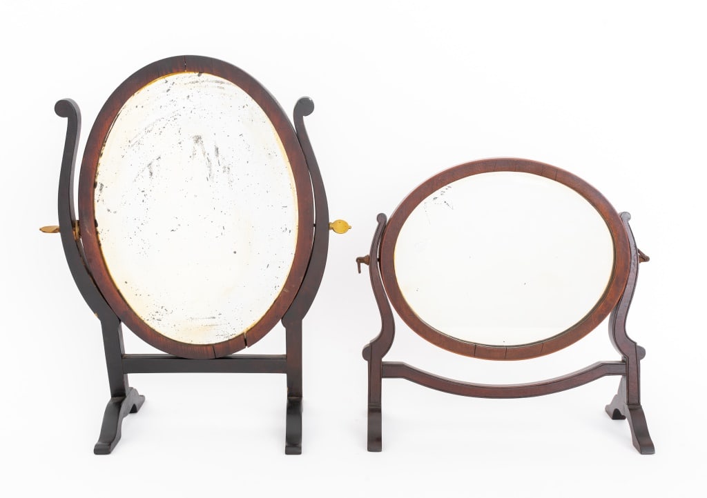 American Mahogany Table Mirrors, 2: Two American Mahogany Table Mirrors, 19th century, each oval with conforming frames. Larger: 16" H x 12" W x 6" D. Provenance: From a New York City Collection. Keywords: Vanity, Dressing table accesso