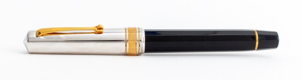 Omas Italy Sterling Silver Fountain Pen: Omas Italy Sterling Silver Fountain Pen, with sterling cap marked "925", with gold-tone metal Greek key motif and black resin barrel. 5.25" H x 0.5" Diameter. Provenance: From a New York City Collecti