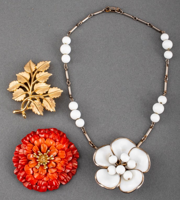 Crown Trifari Costume Jewelry, 3 Pieces: Group Jewelry Lot of Three Pieces of Crown Trifari Costume Jewelry, comprising: one red enameled gold-tone brooch in the form of a chrysanthemum flower, one silver-tone link necklace with white glass