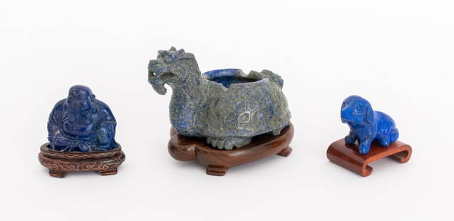 Chinese Carved Lapis & Sodalite Sculptures, 3: Group of Three Chinese Carved Lapis Lazuli and Sodalite Sculptures, comprising: a lapis seated Buddha mounted on stand, a carved seated dog, and a sodalite mythical beast form censer, with wood stands