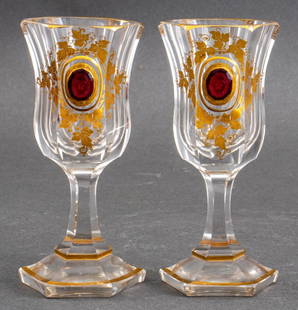 Bohemian Parcel Gilt & Engraved Crystal Glasses, 2: Pair of Bohemian Parcel Gilt and Engraved Crystal Hock Glasses, late 19th century, each centering an applied faceted cranberry glass faux-gem engraved "FF". 5.25" H x 2.5" Diameter. Provenance: Proper