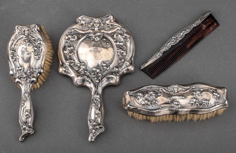 American Art Nouveau Silver Plate Vanity Set, 1905: American Art Nouveau Four-Piece Silver Plate Vanity Set, 1905, comprising two brushes, one comb, and one handheld mirror, all with matching scrolling foliate design with a female figure, the brushes a