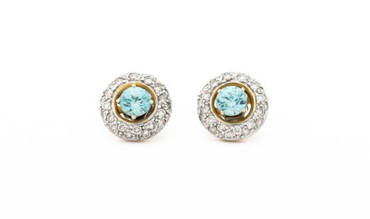 14K Gold Topaz Studs and Diamond Jackets: Pair of 14K Yellow and White Gold Topaz Studs and Diamond Earring Jackets, featuring two prong set round brilliant cut blue topaz weighing a total of approx. 1.20 carats, jackets adorned with forty